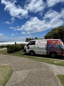 Brightly coloured White, red and blue Moving Canvas Van at Shelly Beach, Sunshine Coast